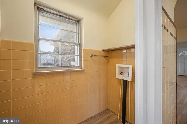 a bathroom with a wooden door and a shower