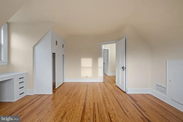 a big room with wooden floor and bathroom view