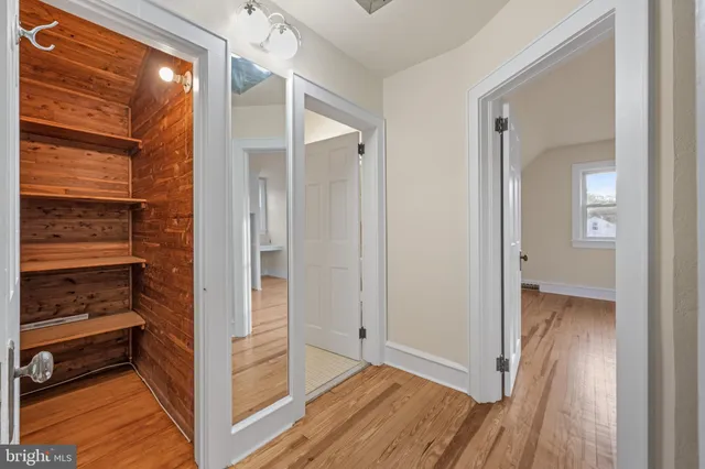 a view of walk in closet with wooden floor