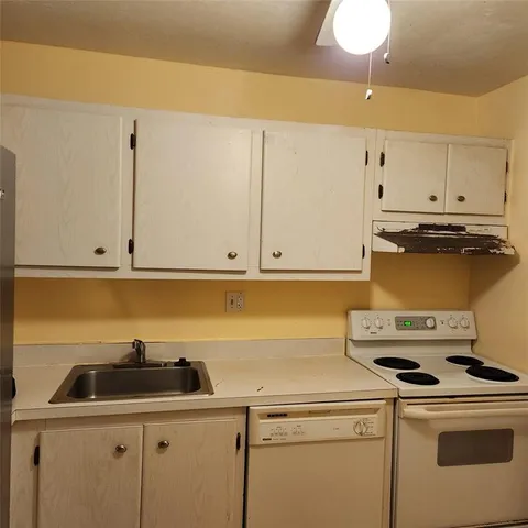 a kitchen with a sink a stove and cabinets