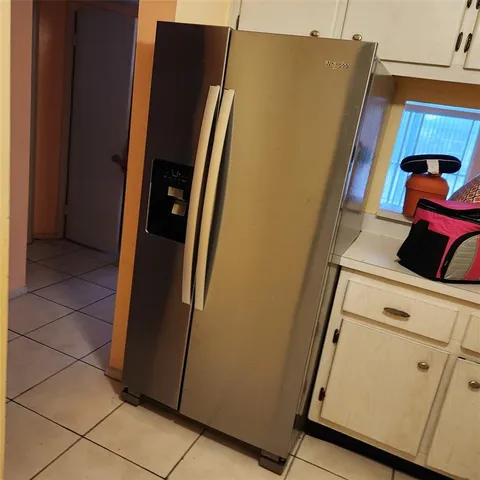 a view of a storage and utility room with refrigerator and washer