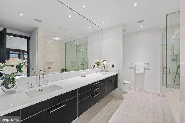 a bathroom with a tub shower sink and mirror