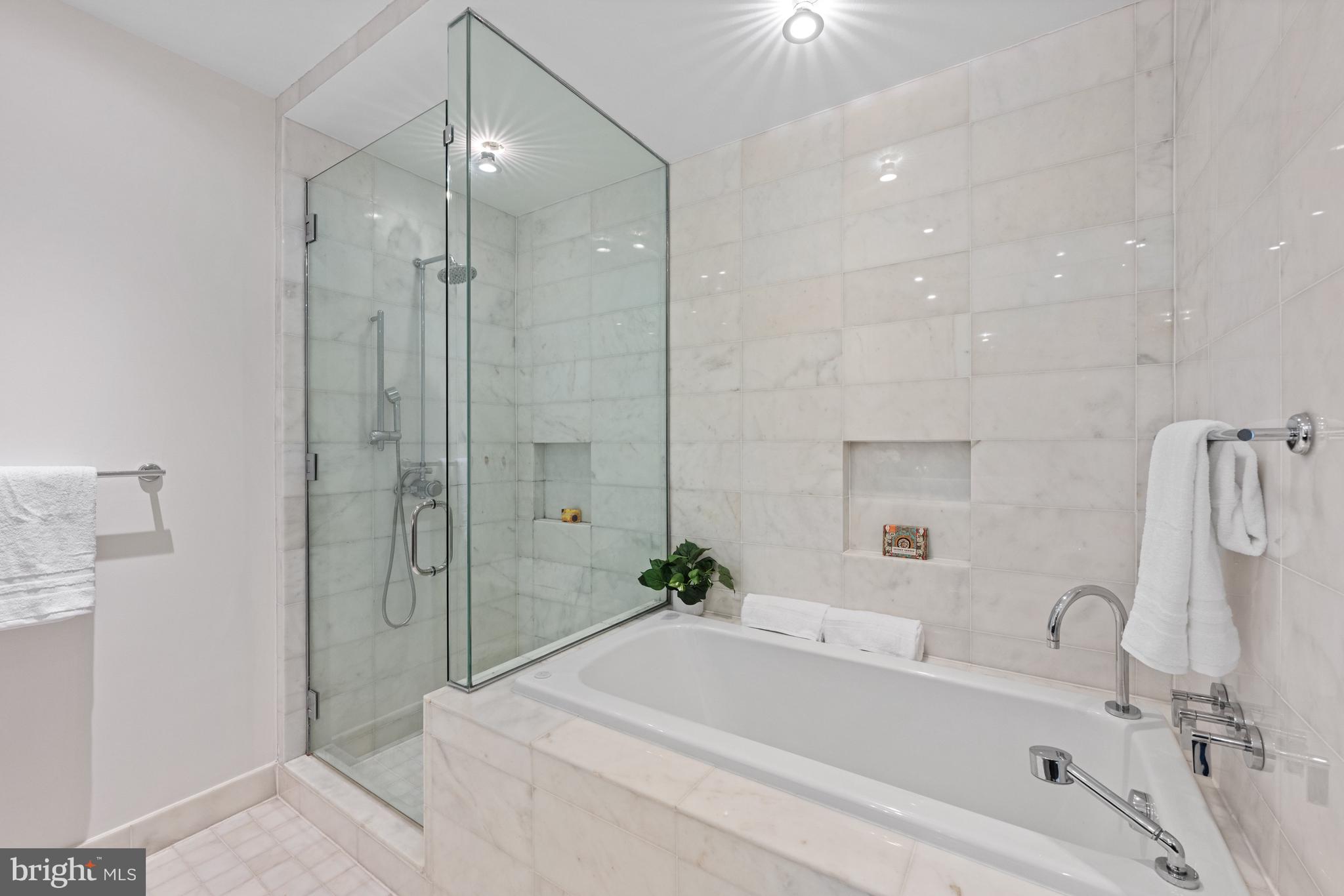 3303 Water Street Northwest, Unit 7E Washington, DC 20007 - Photo 16 of 29 a bathroom with a tub shower sink and mirror