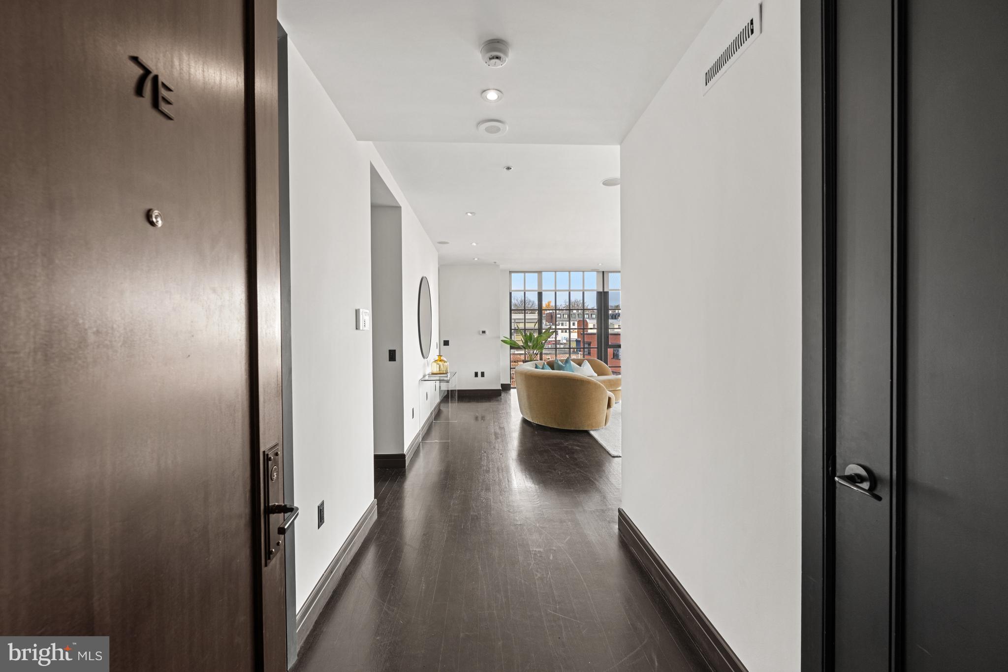 3303 Water Street Northwest, Unit 7E Washington, DC 20007 - Photo 21 of 29 a view of a hallway with wooden floor windows and a livingroom