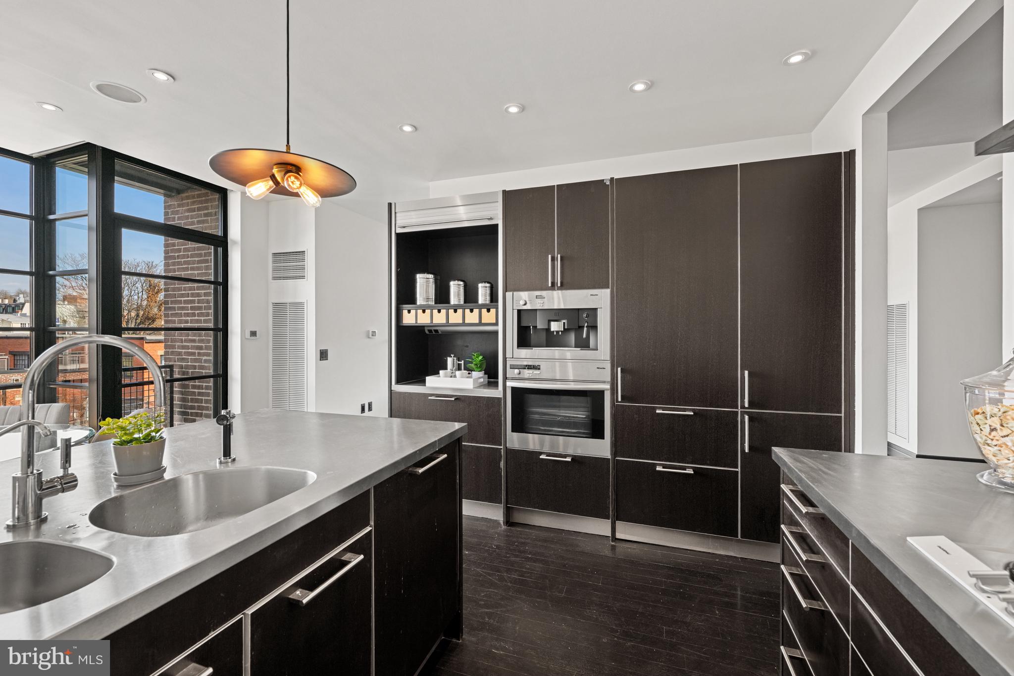 3303 Water Street Northwest, Unit 7E Washington, DC 20007 - Photo 8 of 29 a kitchen with stainless steel appliances granite countertop a sink and a stove