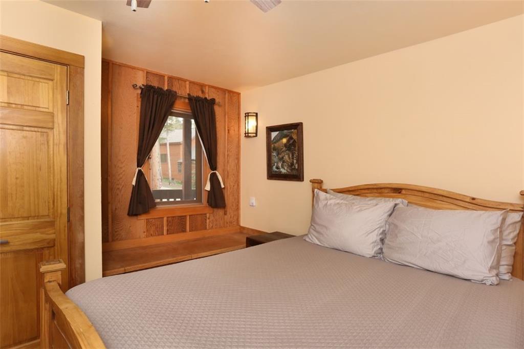 1080 Ski Hill Road, Unit 9 Breckenridge, CO 80424 - Photo 11 of 25 a bedroom with a bed and a flat tv screen on dresser