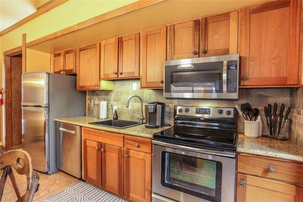 1080 Ski Hill Road, Unit 9 Breckenridge, CO 80424 - Photo 4 of 25 a kitchen with stainless steel appliances granite countertop a stove a sink and a microwave