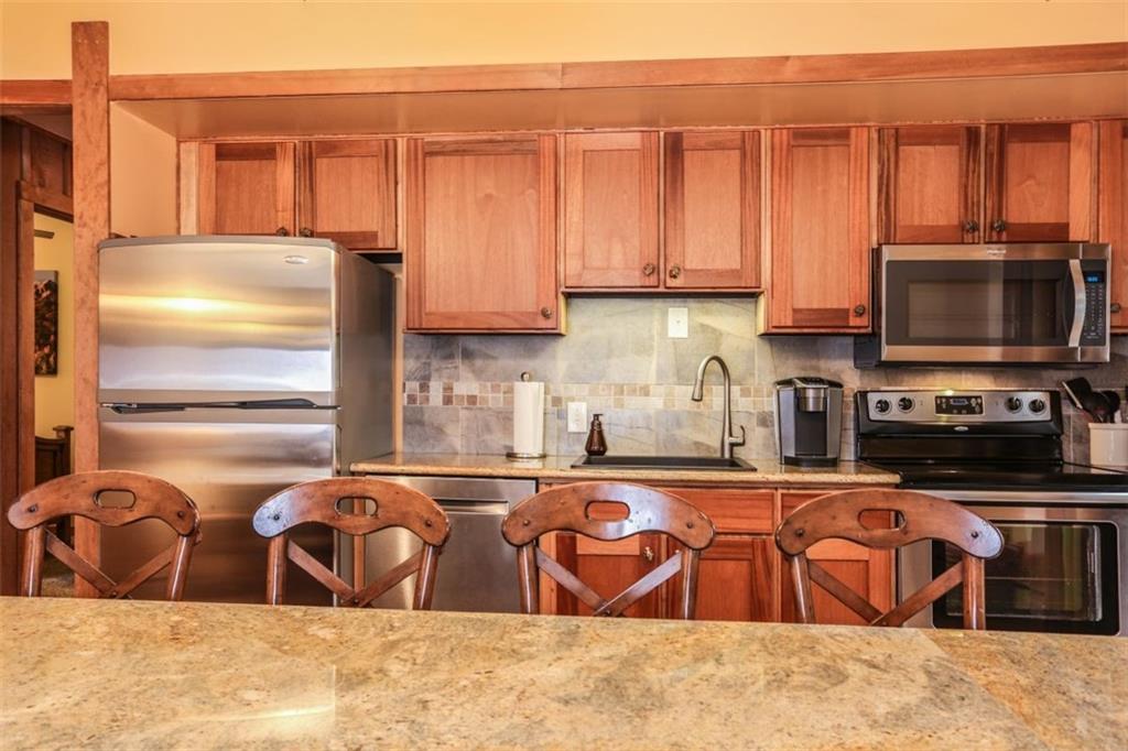 1080 Ski Hill Road, Unit 9 Breckenridge, CO 80424 - Photo 9 of 25 a kitchen with stainless steel appliances granite countertop a refrigerator and microwave