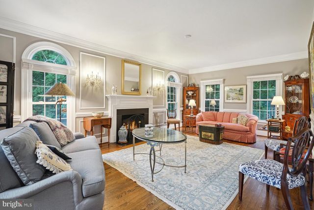a living room with fireplace furniture and a large window