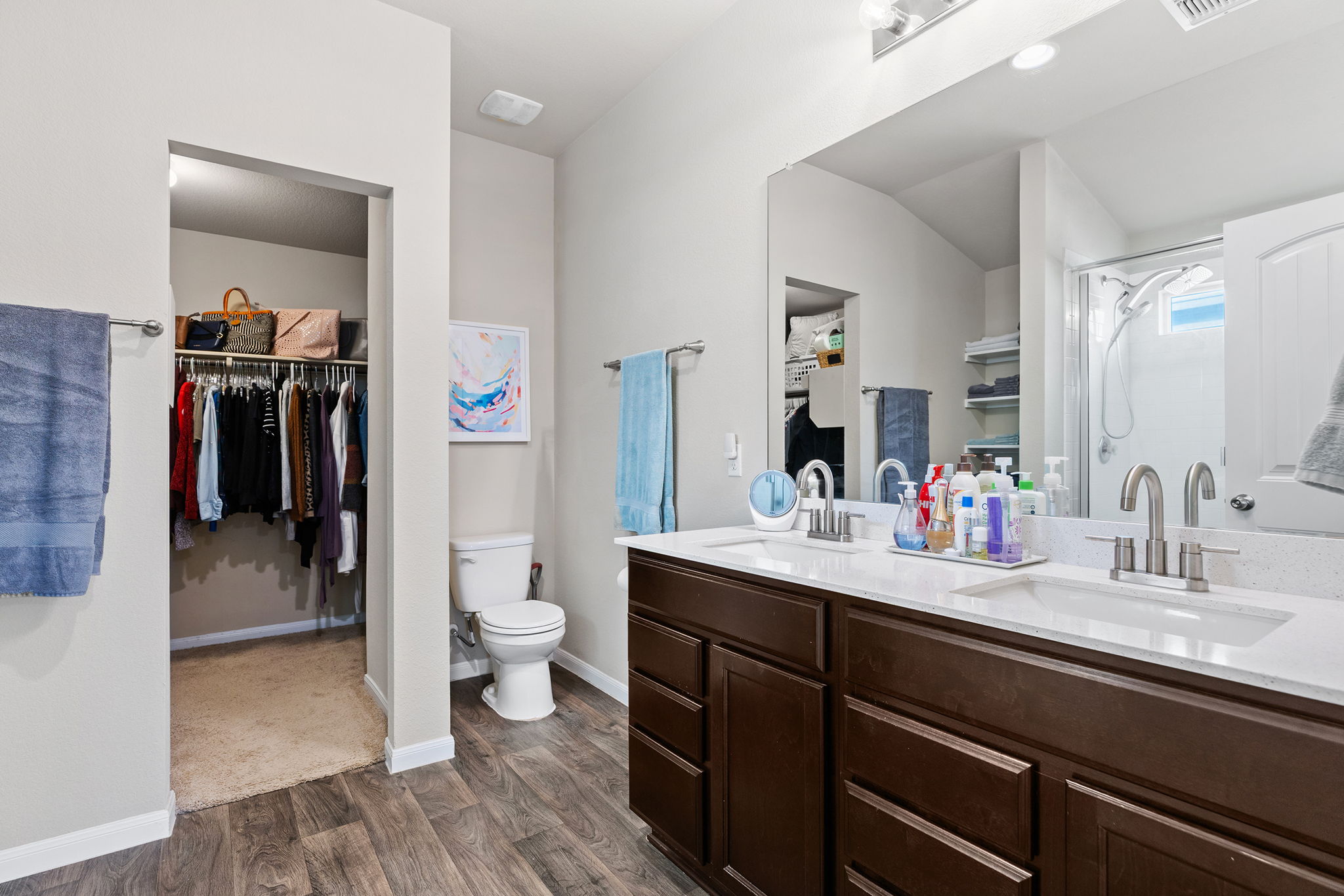 404 Cassandra Drive Hutto, TX 78634 - Photo 19 of 40 Full bathroom with a walk in closet, double vanity, dark wood-type flooring, a shower stall, and vaulted ceiling