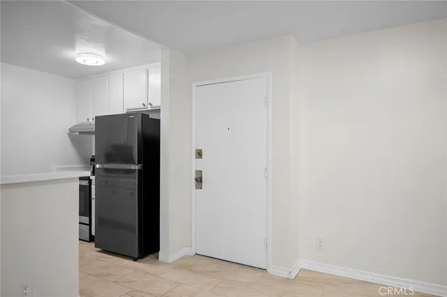 a view of a refrigerator in kitchen and utility room
