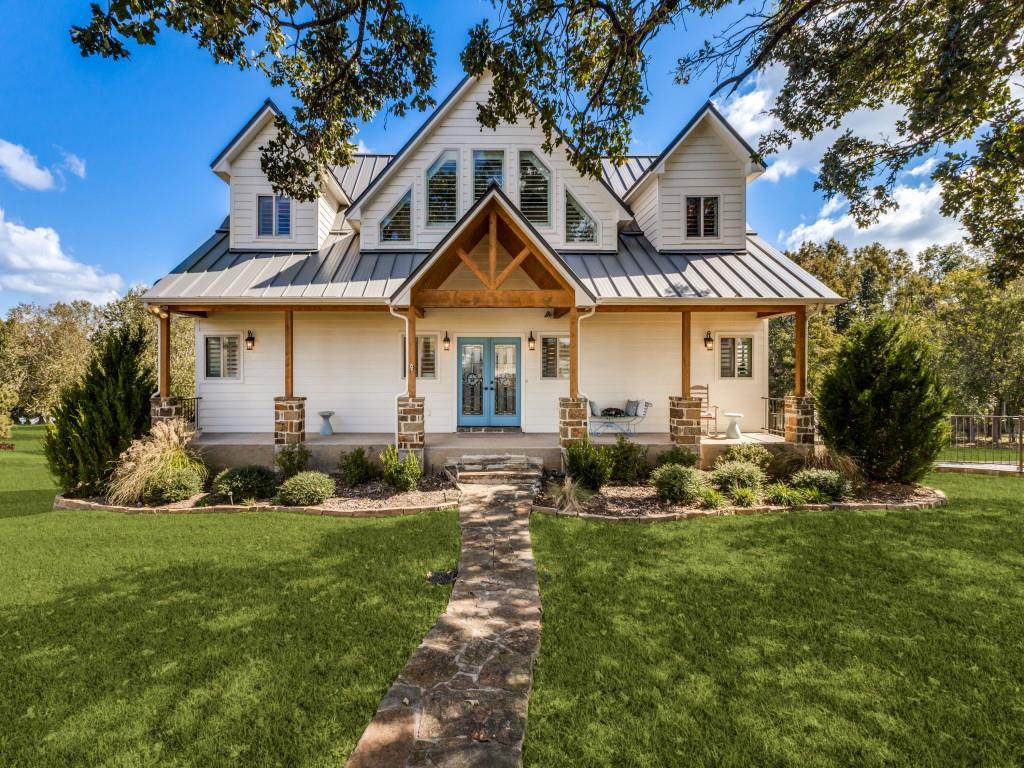 a front view of a house with a yard and green space