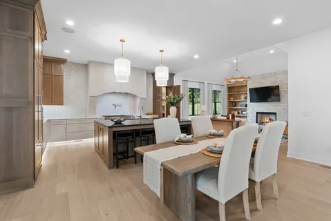 an empty room with wooden floor fireplace and windows