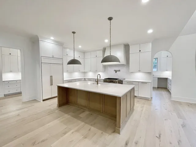 a living room with furniture a flat screen tv and kitchen view