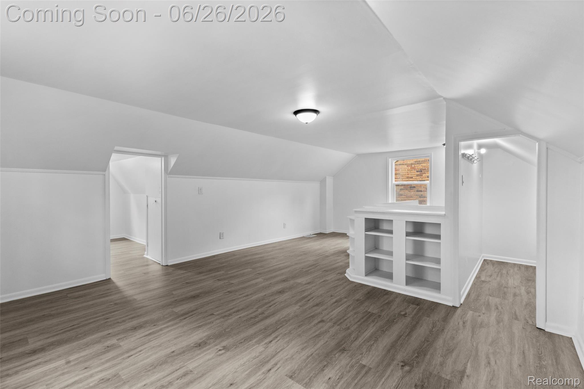 8310 Whitcomb Detroit, MI 48228 - Photo 23 of 26 Spacious attic room featuring wood-finish flooring, built-in shelving, white walls, and sloped ceilings