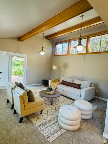 4245 3320 East Holladay, UT 84124 - Photo 15 of 51 Living area featuring exposed wood beams, dual pendant light fixtures, and a wall of transom windows