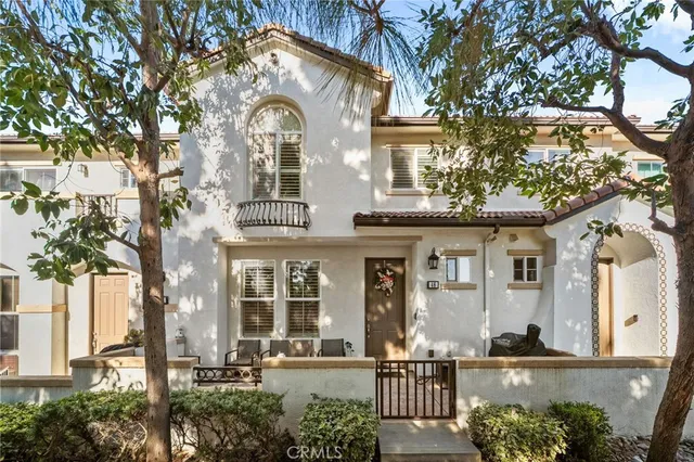 a front view of a house with a tree