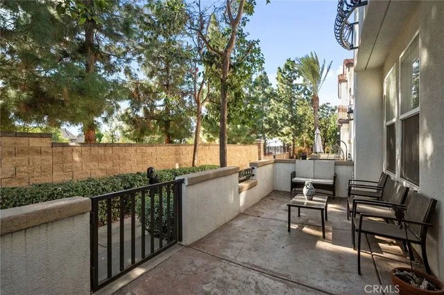a view of a patio with chairs and floor to ceiling window next to a yard