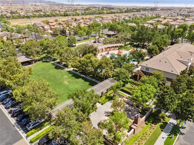 an aerial view of residential houses with outdoor space and trees