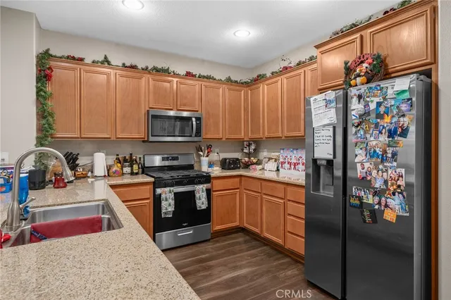 a kitchen with stainless steel appliances granite countertop a refrigerator stove and sink
