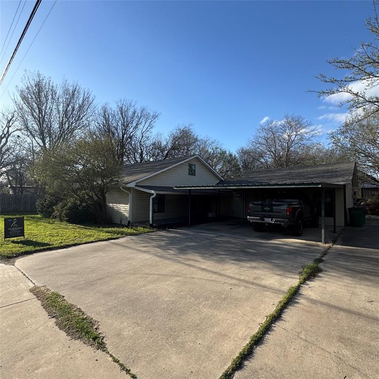 511 Rogers Road Newark, TX 76071 - Photo 16 of 19 View of side of home featuring an attached carport, concrete driveway, and a lawn