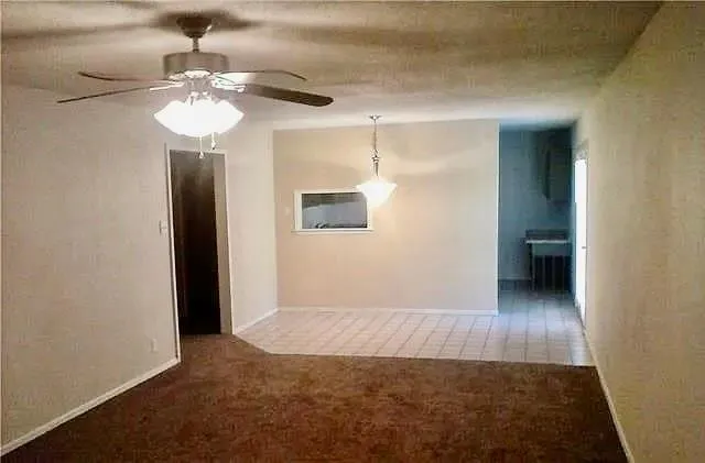 a view of a hallway with wooden floor and chandelier