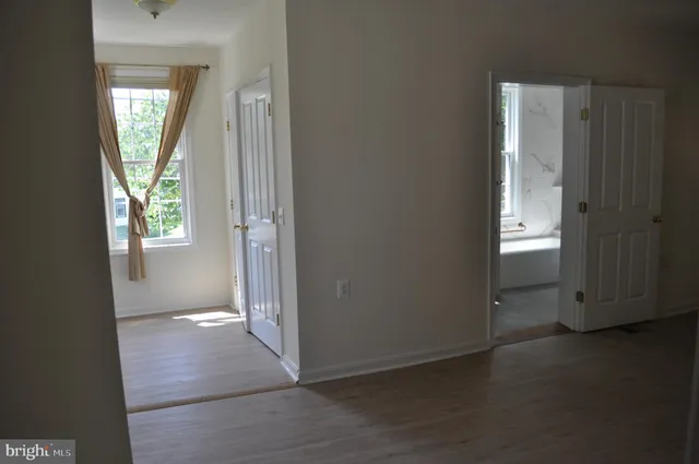 an empty room with windows and closet