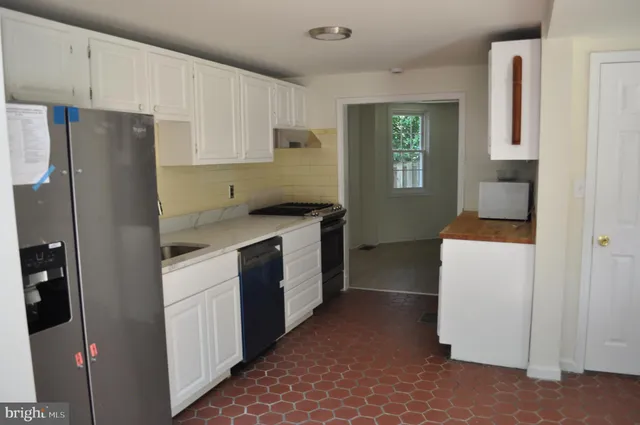 a kitchen with a refrigerator stove and white cabinets