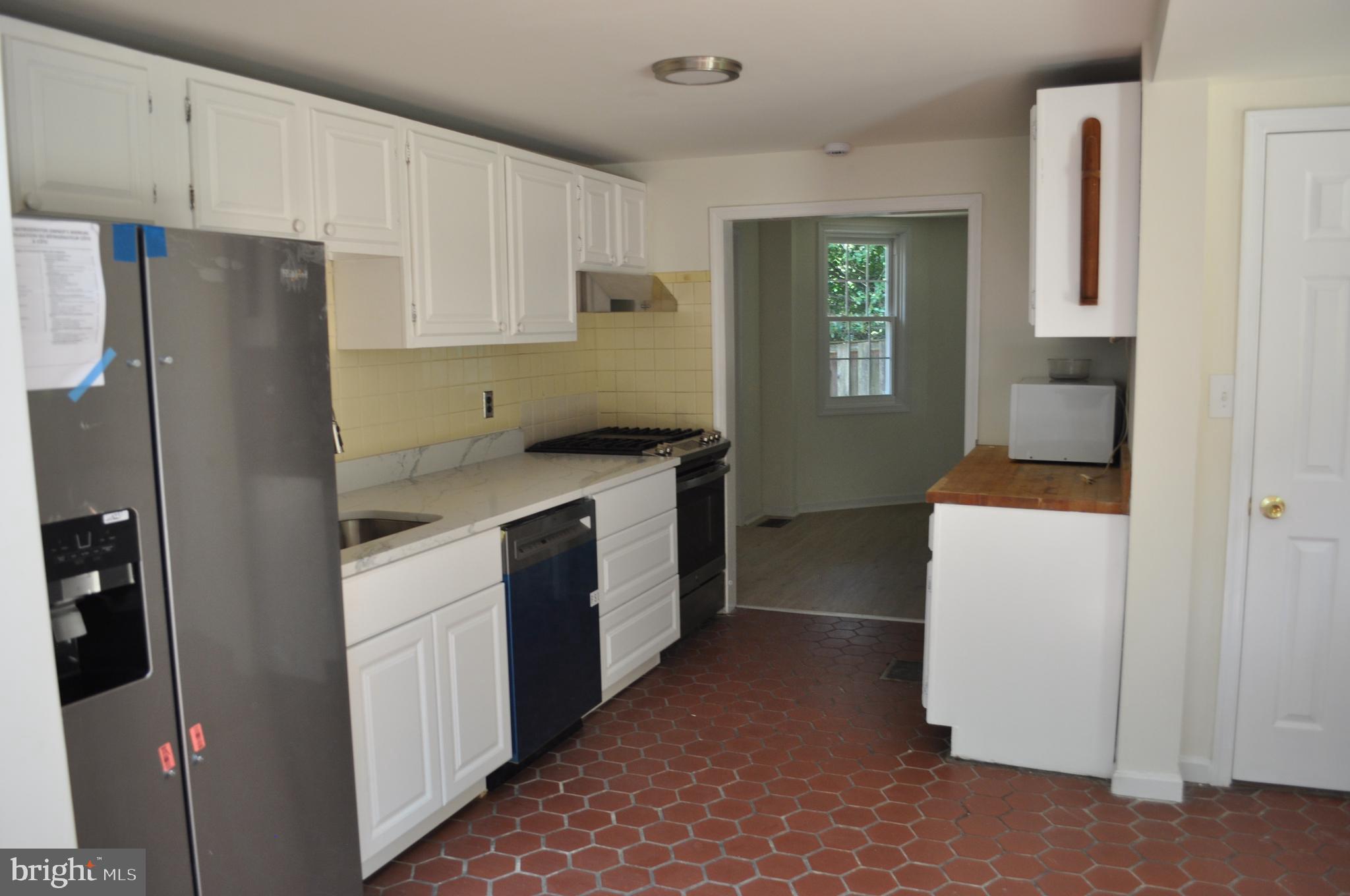 4302 Locust Lane Bethesda, MD 20816 - Photo 9 of 25 a kitchen with a refrigerator stove and white cabinets