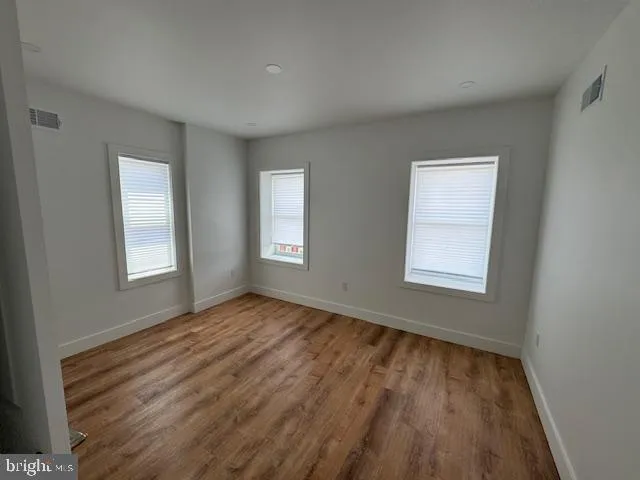 a view of an empty room with wooden floor