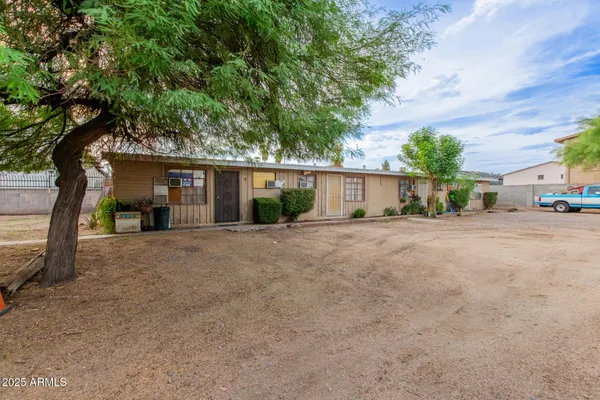 a view of a house with backyard and a tree