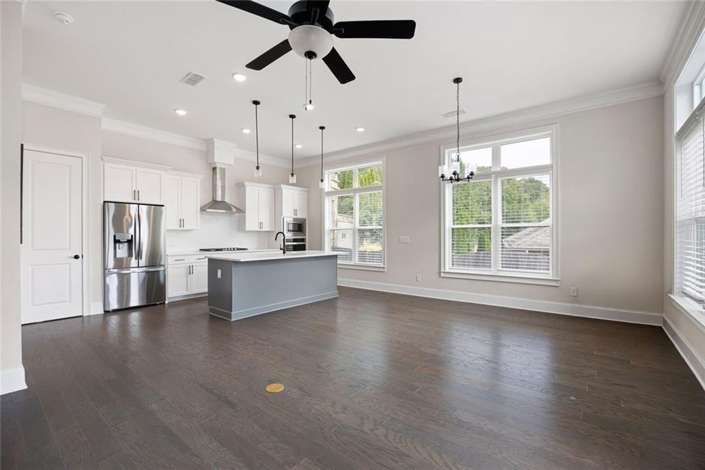 109 Village Green Avenue Woodstock, GA 30189 - Photo 18 of 37 a large kitchen with stainless steel appliances granite countertop a refrigerator a sink dishwasher a stove and a large window with wooden floor