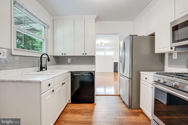 a kitchen with stainless steel appliances granite countertop a refrigerator sink and stove