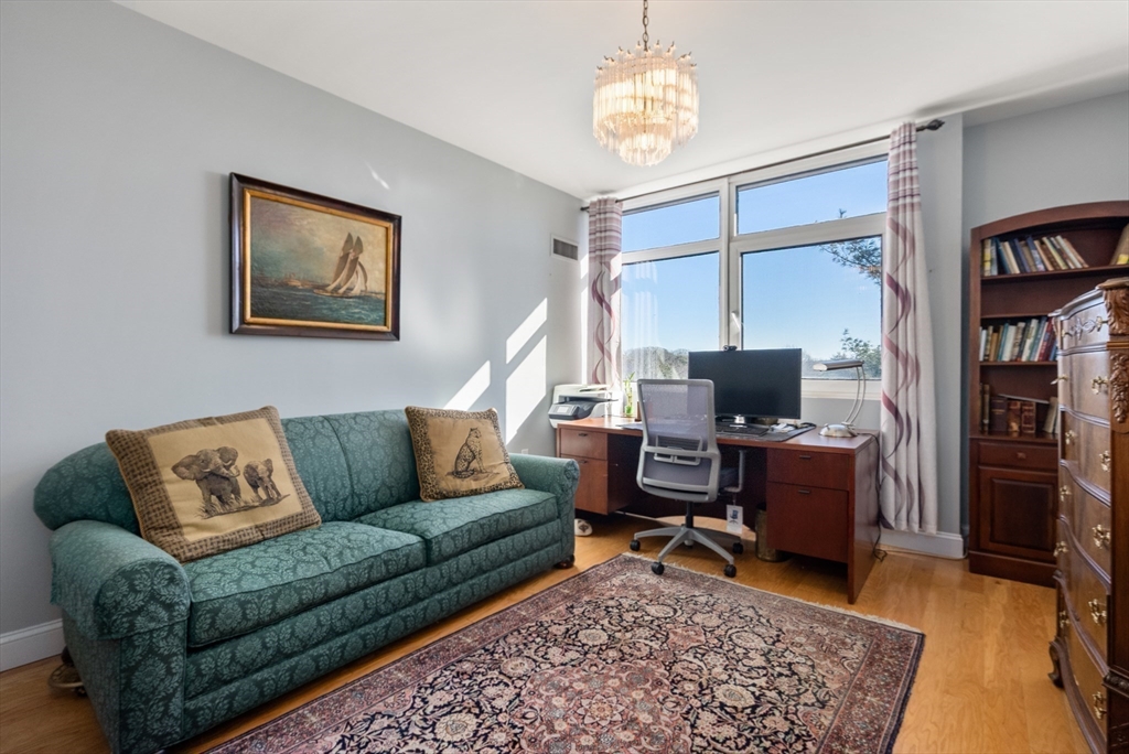 79 Florence Street, Unit 508S Newton, MA 02467 - Photo 12 of 20 a living room with furniture a rug and a bookshelf