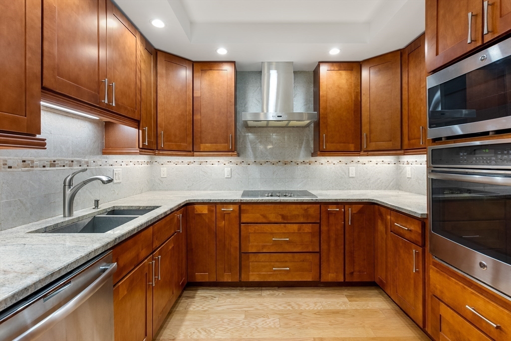 79 Florence Street, Unit 508S Newton, MA 02467 - Photo 5 of 20 a kitchen with stainless steel appliances granite countertop wooden cabinets a stove top oven a sink and dishwasher