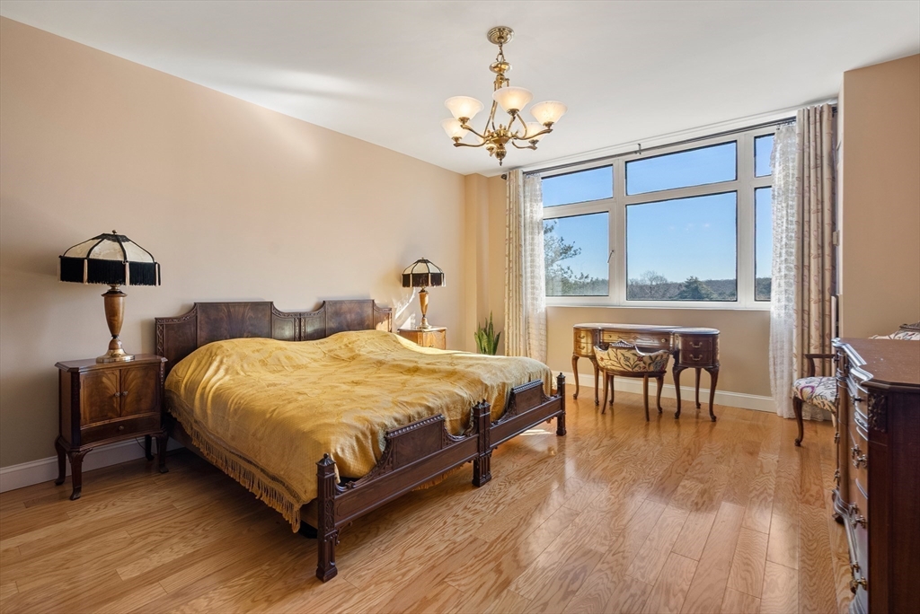 79 Florence Street, Unit 508S Newton, MA 02467 - Photo 8 of 20 a bedroom with a bed wooden floor and a table