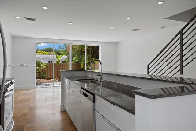 a kitchen with a sink and large windows
