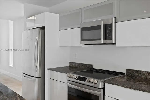 a kitchen with stainless steel appliances granite countertop a refrigerator and a stove