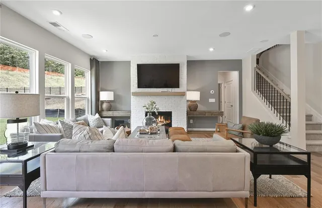 a living room with furniture a flat screen tv and a fireplace