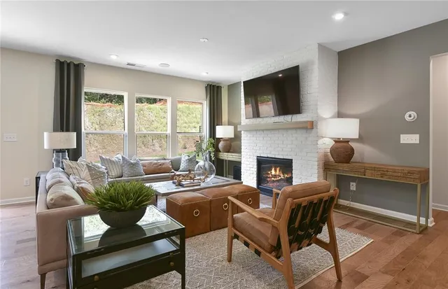 a living room with fireplace furniture and a large window