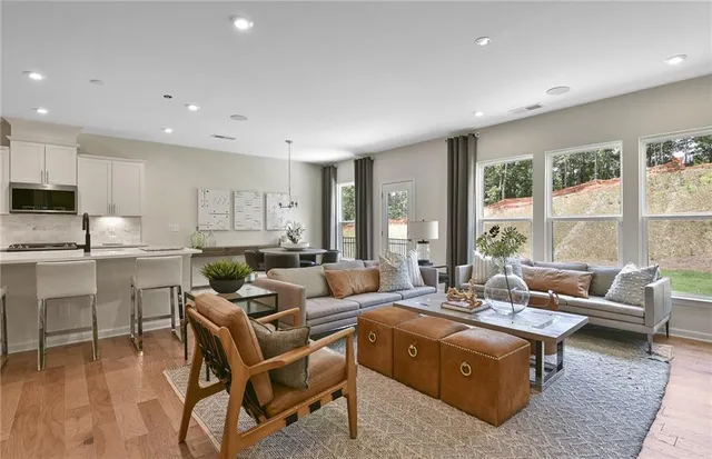 a living room with furniture and a view of kitchen