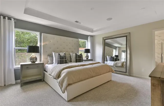 a spacious bedroom with a bed and large mirror