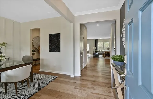 a view of a hallway with wooden floor and a potted plant