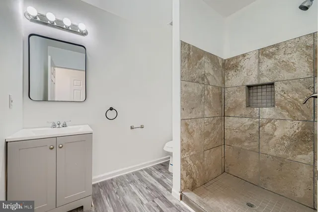 a bathroom with a mirror a shower and vanity