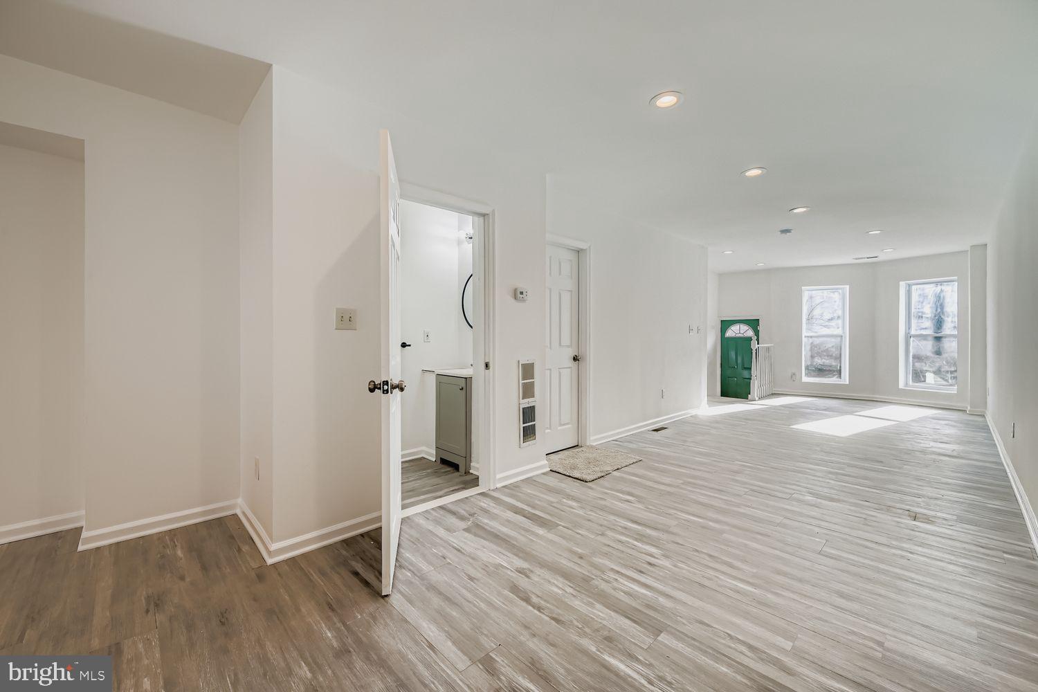 1006 East 20th Street Baltimore, MD 21218 - Photo 6 of 29 a view of an empty room with wooden floor and a window