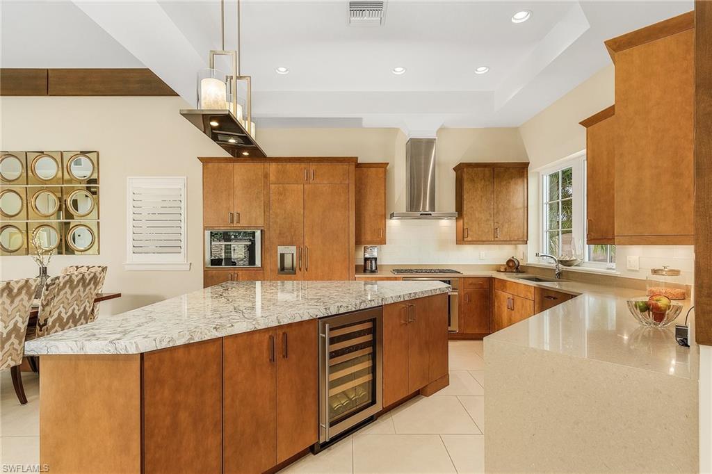 9149 Mercato Way Naples, FL 34108 - Photo 11 of 47 a large kitchen with a counter top space a sink stainless steel appliances and cabinets