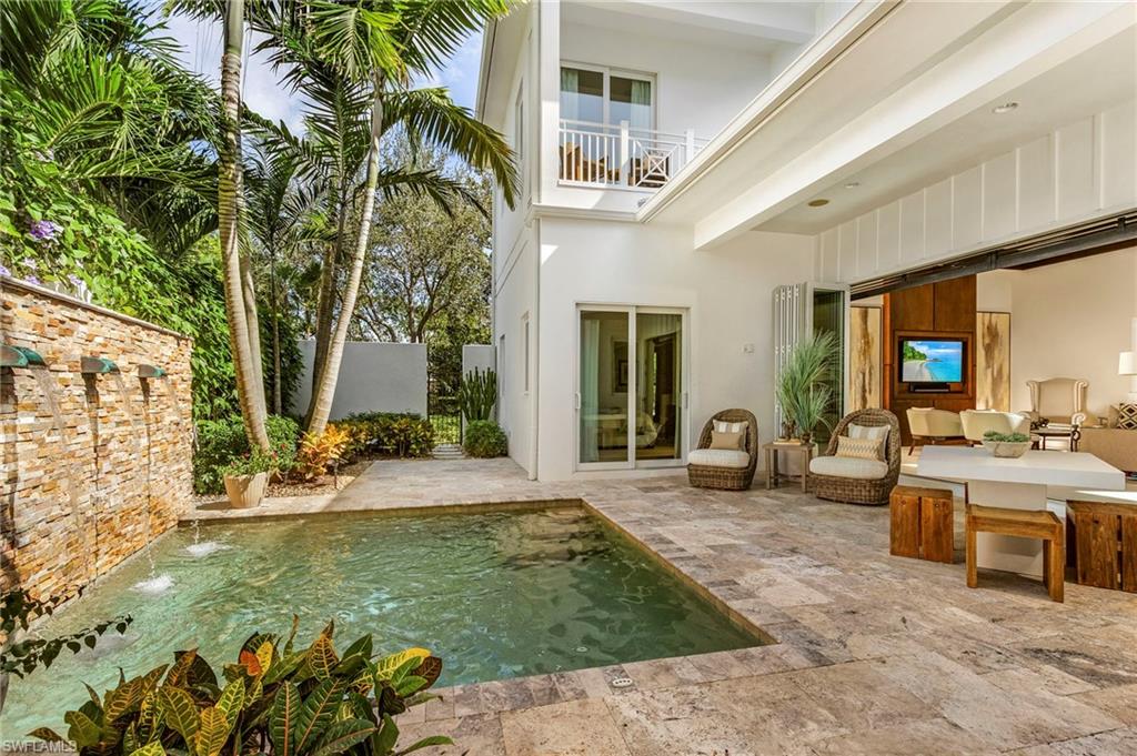 9149 Mercato Way Naples, FL 34108 - Photo 16 of 47 a view of a patio with table and chairs potted plants and large tree