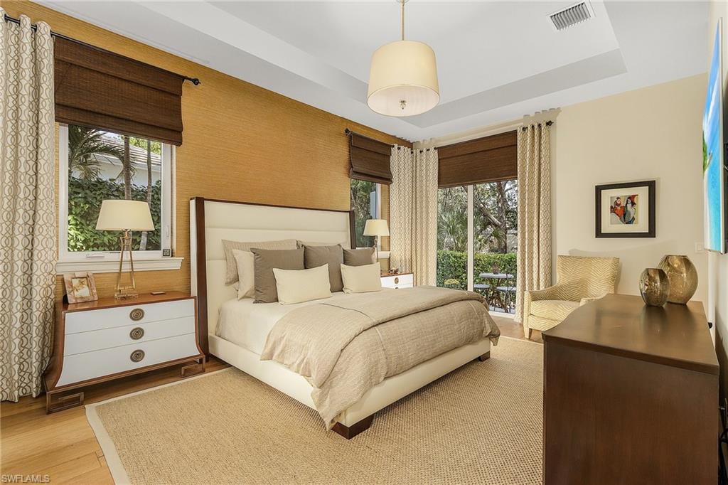 9149 Mercato Way Naples, FL 34108 - Photo 20 of 47 a bedroom with a bed and a chandelier