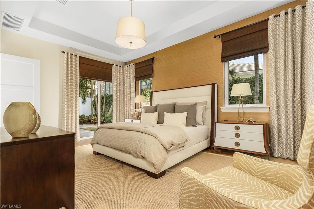 9149 Mercato Way Naples, FL 34108 - Photo 21 of 47 a bedroom with a large bed and windows