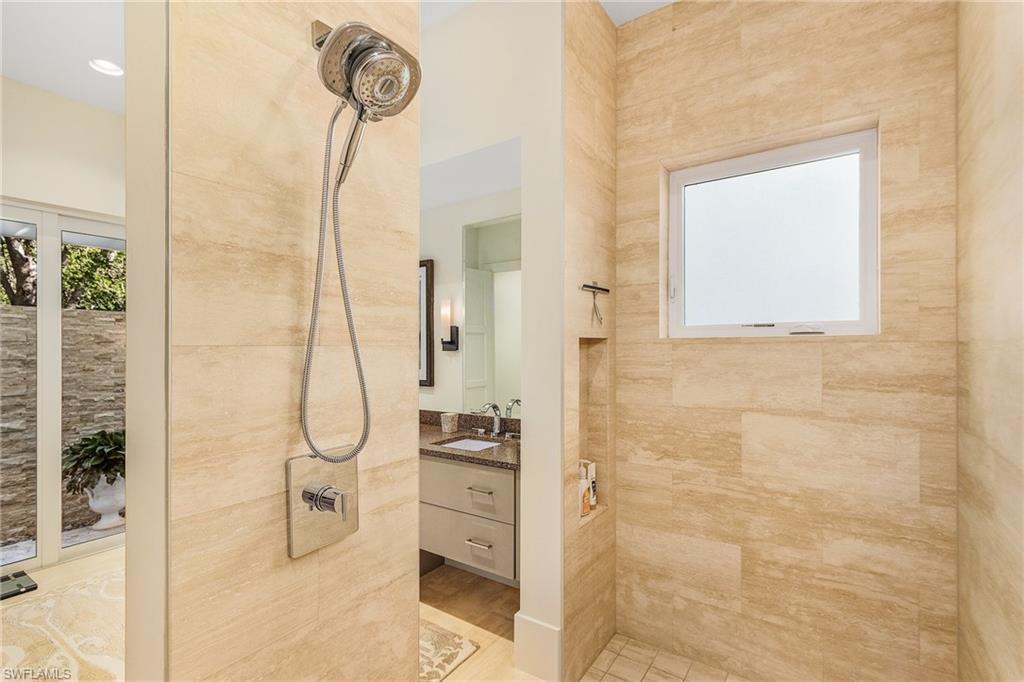 9149 Mercato Way Naples, FL 34108 - Photo 25 of 47 a bathroom with a shower a mirror and a sink